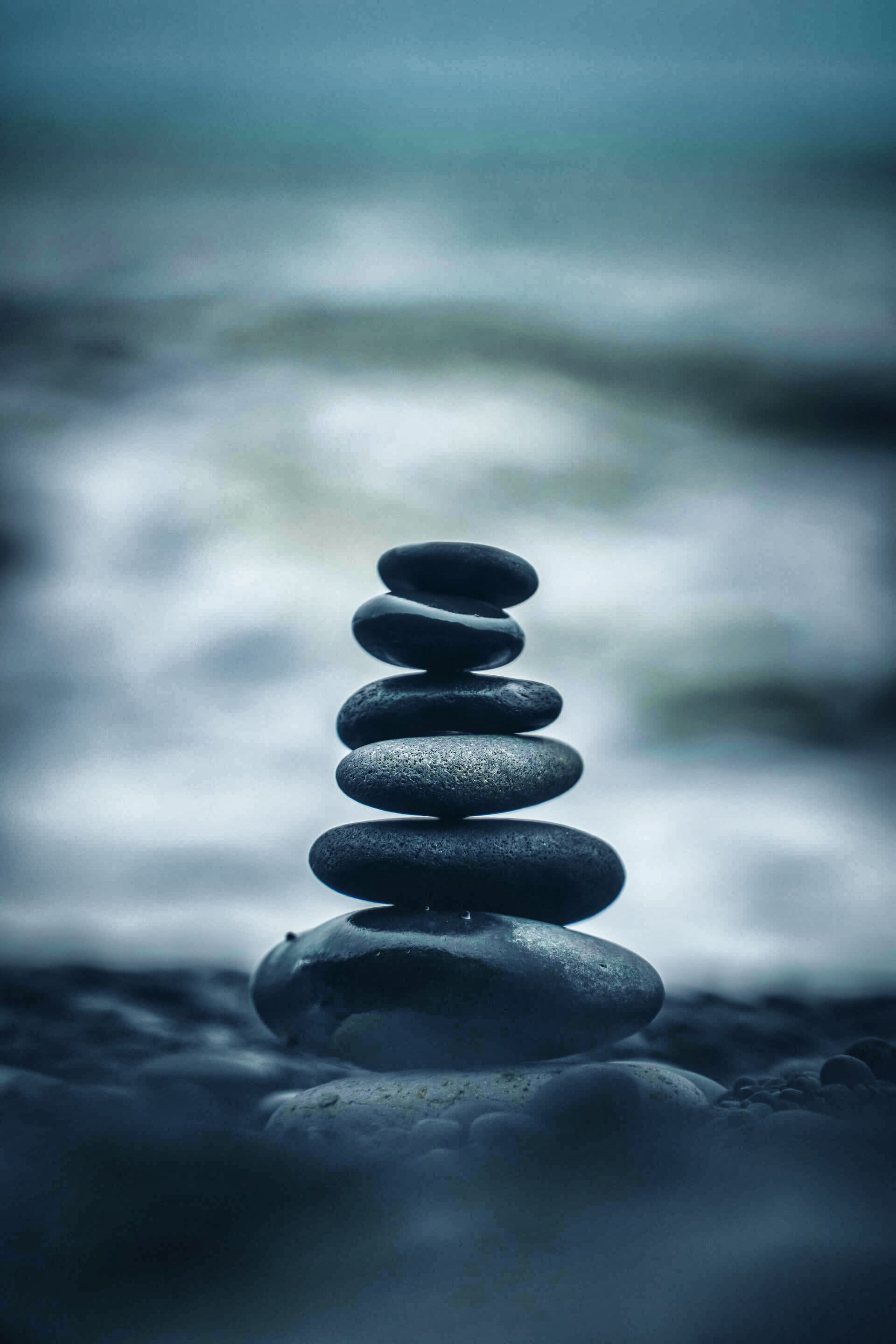 Stacked pebbles on a stony beach symbolising the right inner path and good mental health